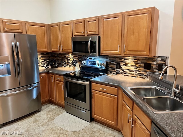 kitchen with light tile patterned flooring, sink, appliances with stainless steel finishes, and tasteful backsplash