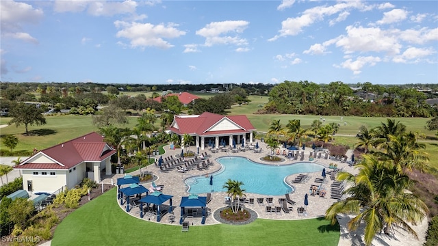 view of pool with a patio and a lawn