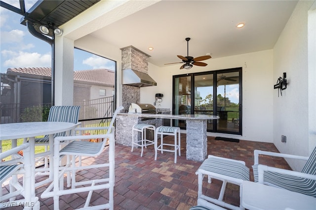 view of patio / terrace with area for grilling, ceiling fan, and exterior bar