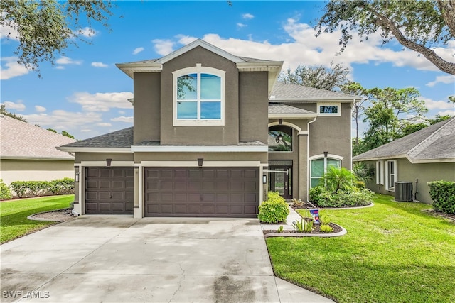 view of property featuring a garage, central air condition unit, and a front lawn