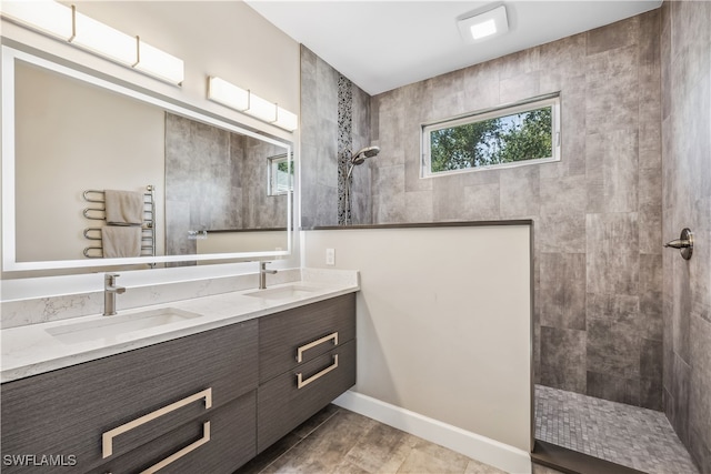 bathroom featuring tile patterned floors, vanity, and tiled shower