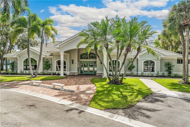 view of front of property featuring french doors and a front lawn