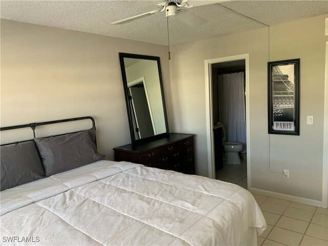 bedroom featuring ensuite bath, a textured ceiling, tile patterned flooring, and ceiling fan