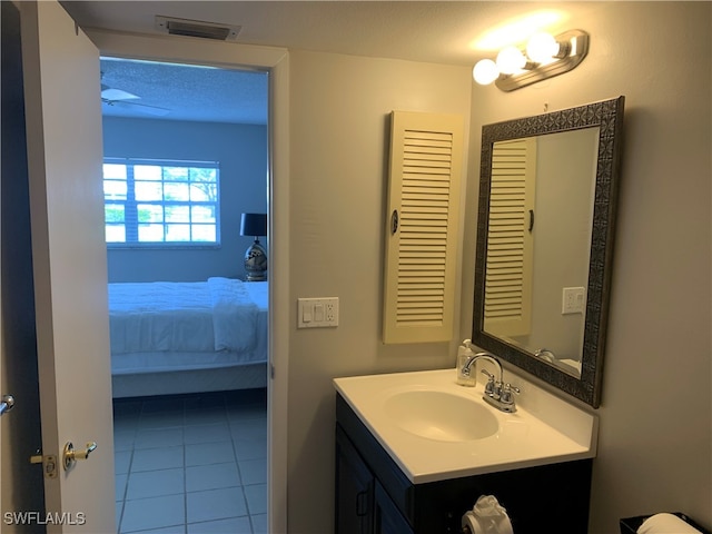 bathroom with vanity, a textured ceiling, and tile patterned flooring