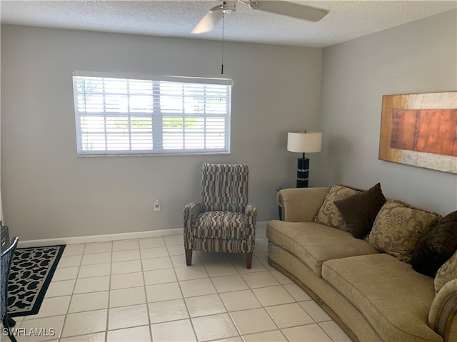 tiled living room with ceiling fan and a textured ceiling