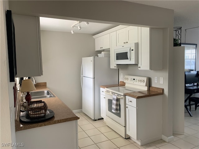 kitchen featuring white appliances, light tile patterned floors, sink, white cabinets, and track lighting