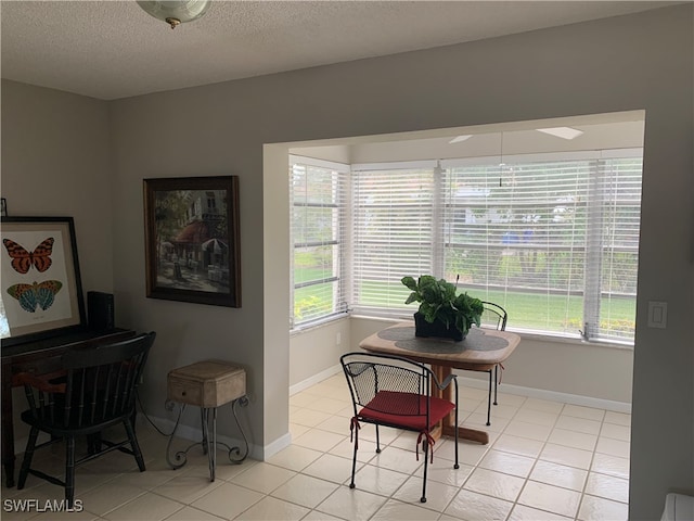 dining area with light tile patterned flooring and a textured ceiling