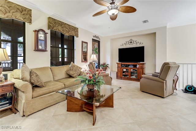 tiled living room with ceiling fan and ornamental molding