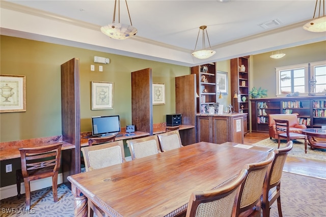 dining space featuring light hardwood / wood-style flooring and crown molding