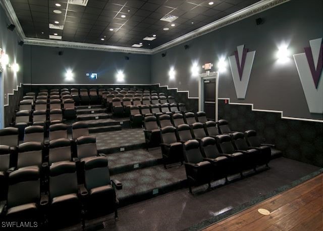 cinema room with hardwood / wood-style floors and a drop ceiling