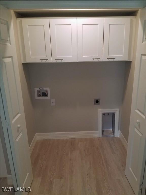 clothes washing area with cabinets, hookup for a washing machine, hardwood / wood-style flooring, and electric dryer hookup