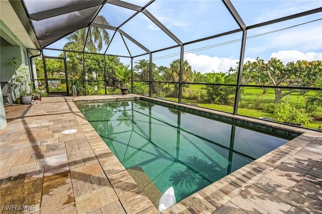 view of swimming pool featuring glass enclosure and a patio