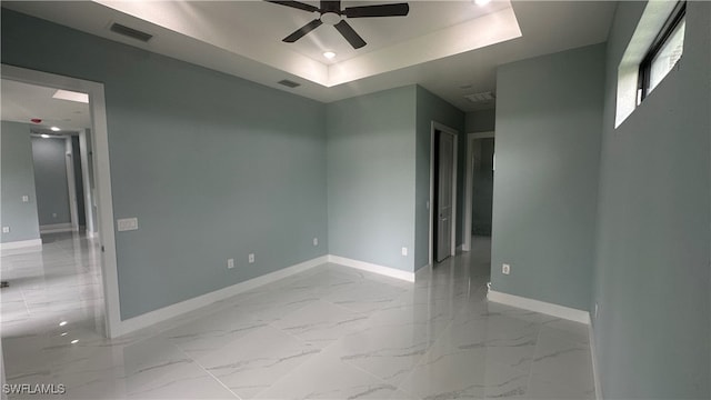 spare room featuring ceiling fan and a tray ceiling