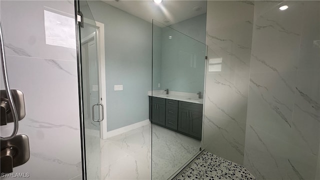 bathroom featuring a shower with door and vanity