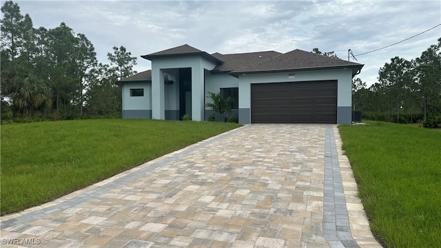 view of front of home with a garage and a front lawn