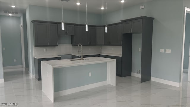 kitchen with a center island with sink, sink, and decorative light fixtures