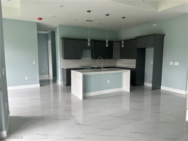 kitchen with sink, a kitchen island with sink, and pendant lighting