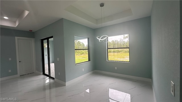 unfurnished room featuring a raised ceiling