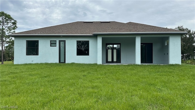 rear view of property featuring a lawn