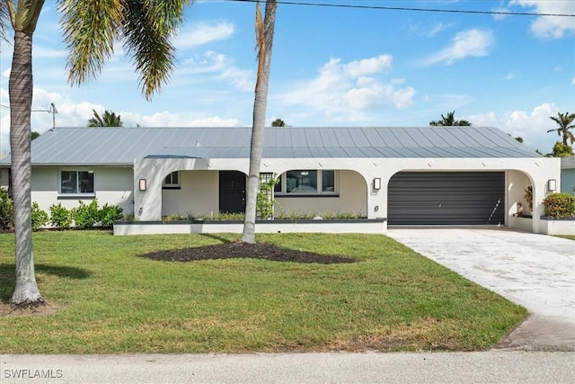 ranch-style home with a garage, a front yard, concrete driveway, and stucco siding