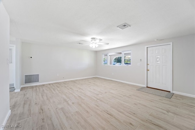 interior space featuring a textured ceiling, light hardwood / wood-style floors, and ceiling fan