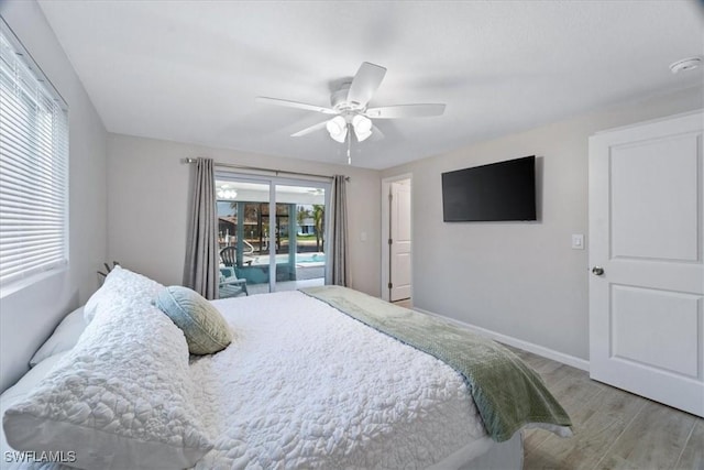 bedroom featuring baseboards, wood finished floors, a ceiling fan, and access to exterior