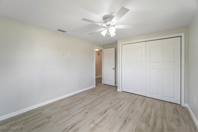 unfurnished bedroom featuring light hardwood / wood-style floors, a closet, and ceiling fan