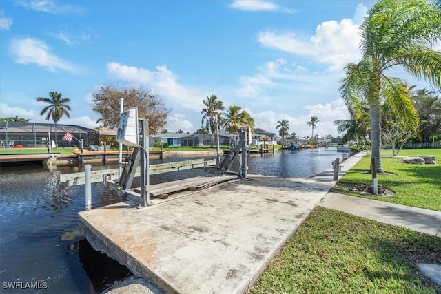 view of dock featuring a lawn, a water view, boat lift, and a residential view