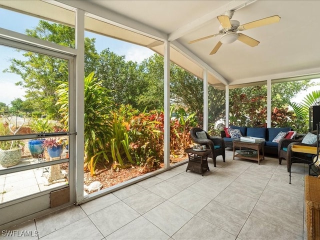 sunroom featuring lofted ceiling with beams, plenty of natural light, and ceiling fan