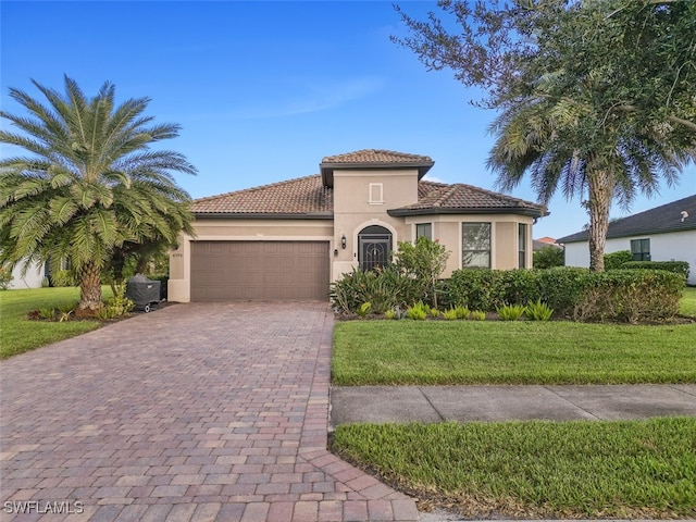 mediterranean / spanish house with a front lawn and a garage