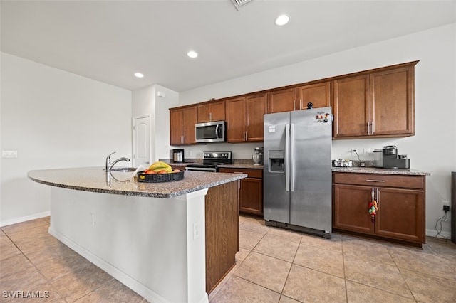 kitchen featuring appliances with stainless steel finishes, sink, light tile patterned floors, and an island with sink