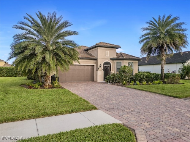 mediterranean / spanish-style home featuring a garage and a front lawn