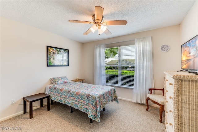 bedroom with a textured ceiling, light colored carpet, and ceiling fan