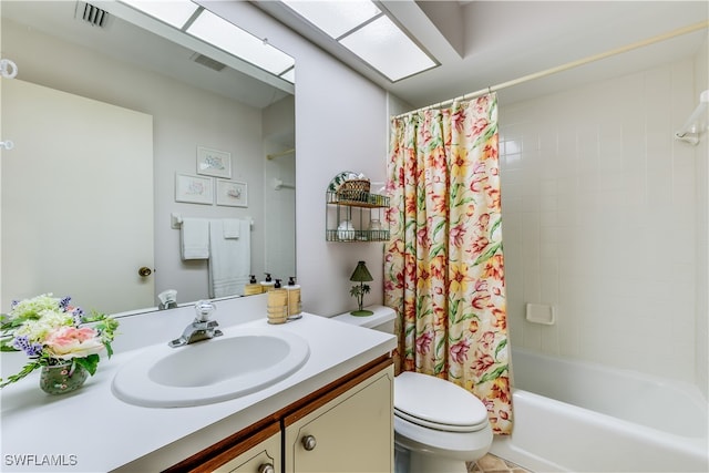 full bathroom with vanity, shower / tub combo with curtain, and toilet