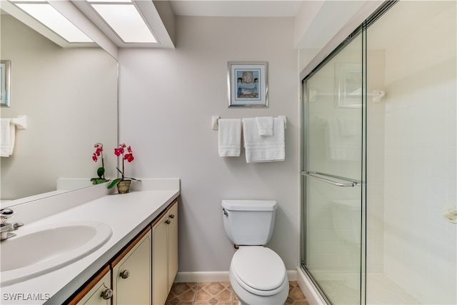 bathroom with toilet, a shower with shower door, vanity, and tile patterned flooring