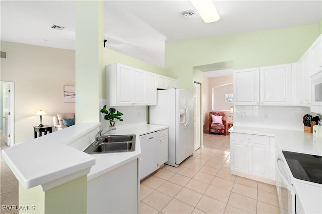 kitchen featuring white appliances, white cabinets, sink, kitchen peninsula, and light tile patterned floors