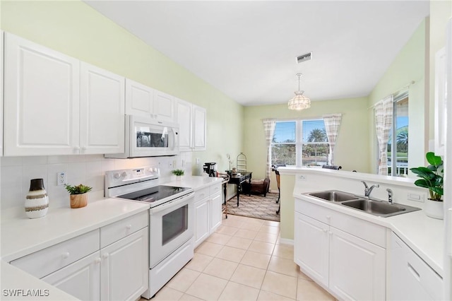 kitchen featuring white appliances, white cabinetry, light tile patterned floors, sink, and decorative light fixtures