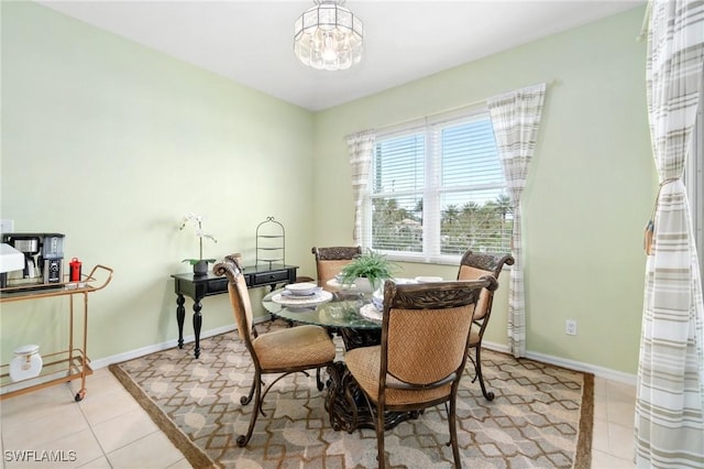 tiled dining room featuring an inviting chandelier