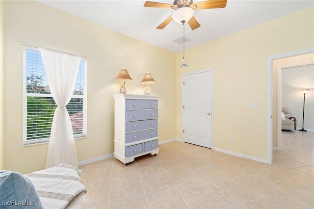 tiled bedroom featuring ceiling fan