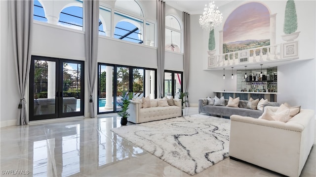 living room with a chandelier, ornamental molding, french doors, and a high ceiling