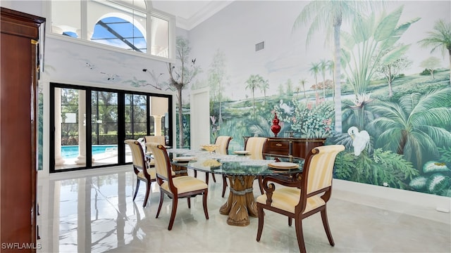 dining space with french doors, crown molding, and a towering ceiling