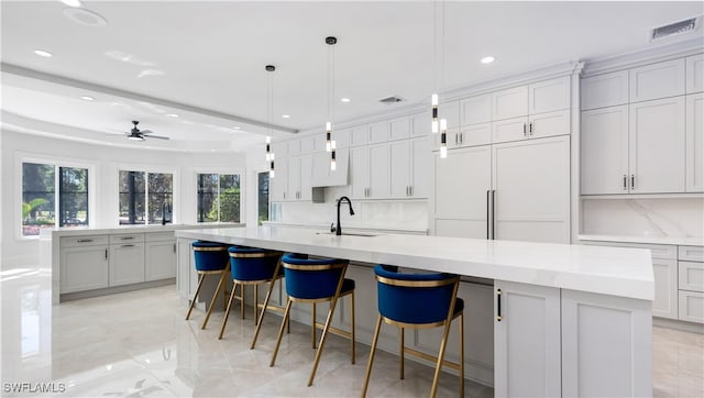 kitchen with a large island, sink, and hanging light fixtures