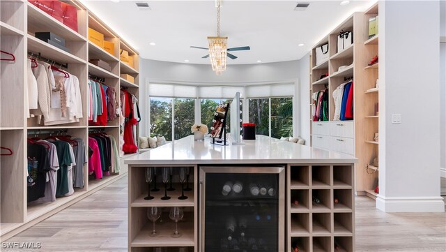 walk in closet with light hardwood / wood-style flooring, wine cooler, and ceiling fan