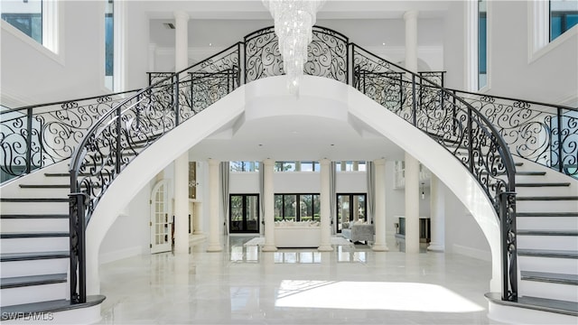 entrance foyer featuring an inviting chandelier, a high ceiling, french doors, and decorative columns