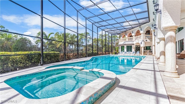 view of pool featuring an in ground hot tub, a patio, and a lanai