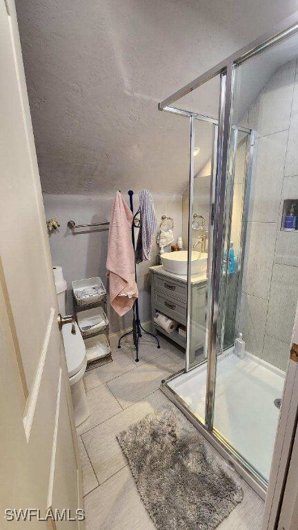 bathroom featuring toilet, an enclosed shower, vanity, and tile patterned floors