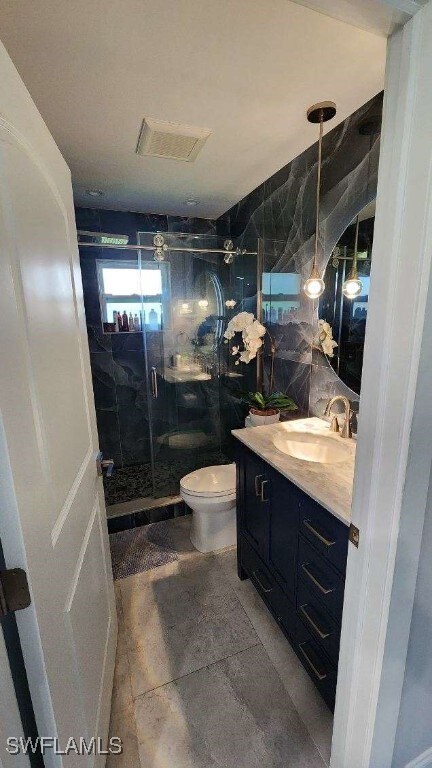 bathroom featuring vanity, toilet, tile walls, and an enclosed shower