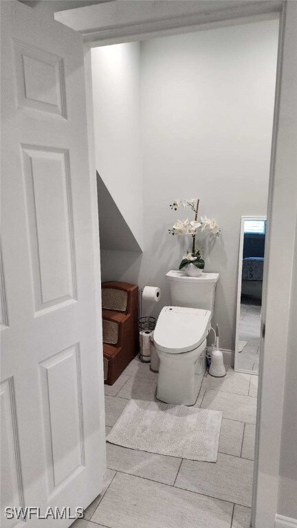 bathroom with toilet and tile patterned flooring