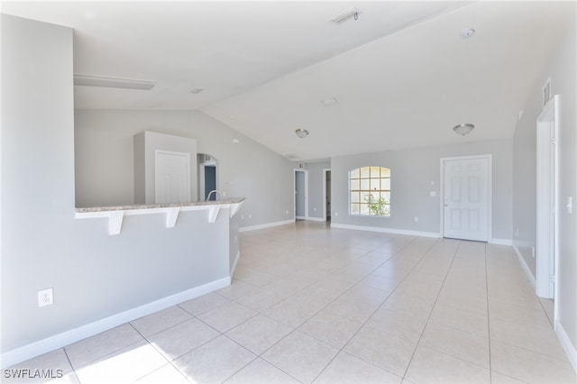 unfurnished living room with light tile patterned flooring and lofted ceiling