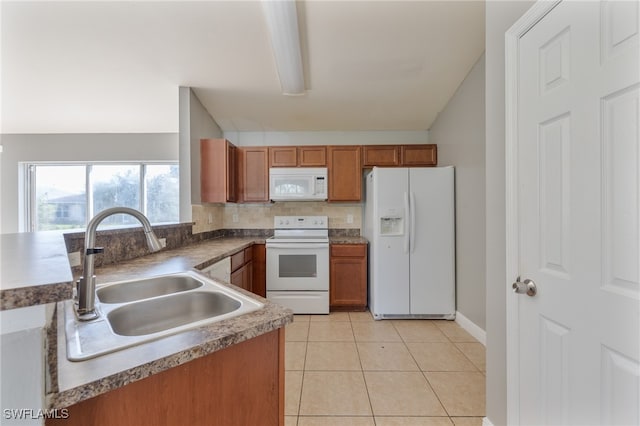 kitchen with sink, light tile patterned floors, backsplash, and white appliances